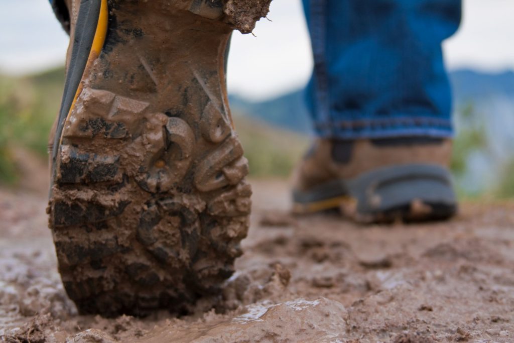 Een close-up van wandelschoenen in de modder.