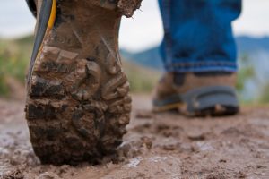 Een close-up van wandelschoenen in de modder.